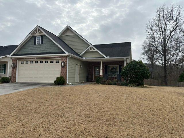 craftsman house with a garage and a front lawn