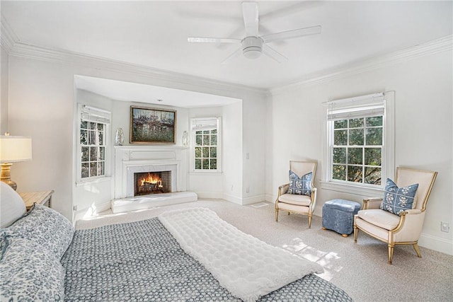 carpeted bedroom with baseboards, a lit fireplace, and crown molding