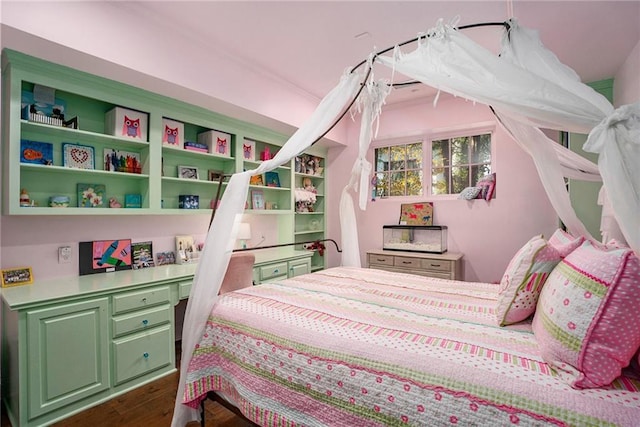 bedroom with dark wood finished floors and built in study area