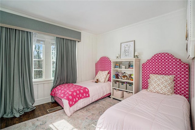 bedroom featuring crown molding, wood finished floors, and visible vents