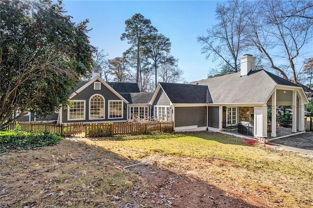 view of front of property featuring a fenced front yard and a chimney