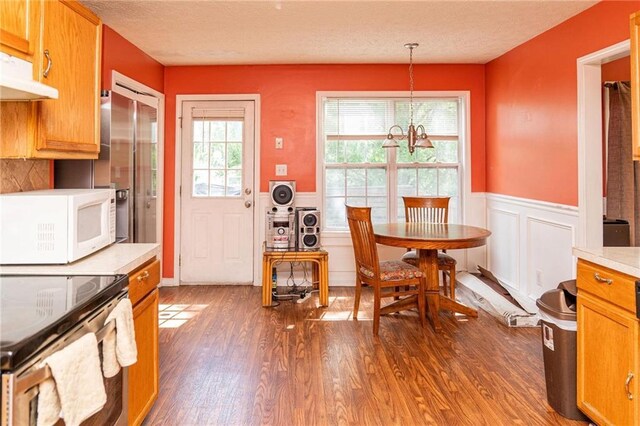 68 Paradise Pointe, Douglasville, GA 30134 - dining space featuring wood finished floors, a wainscoted wall, a chandelier, and a decorative wall