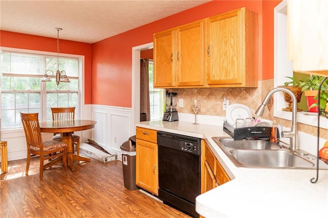 68 Paradise Pointe, Douglasville, GA 30134 - kitchen featuring black dishwasher, a sink, light countertops, wood finished floors, and wainscoting