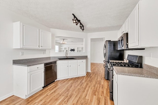 1186 Hawthorn Ln, Grayson, GA 30017 - kitchen with appliances with stainless steel finishes, a sink, light wood-style flooring, white cabinets, and a textured ceiling
