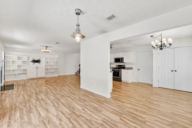 1186 Hawthorn Ln, Grayson, GA 30017 - unfurnished living room with a textured ceiling, light wood finished floors, a chandelier, and baseboards