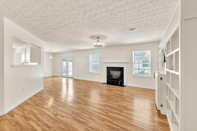 1186 Hawthorn Ln, Grayson, GA 30017 - unfurnished living room with light wood-type flooring, baseboards, a fireplace, and a textured ceiling