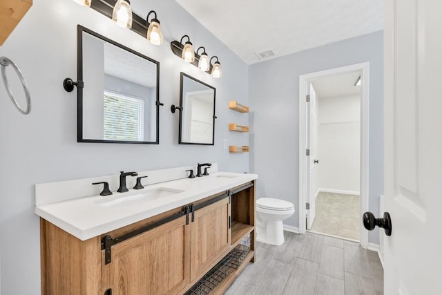 1186 Hawthorn Ln, Grayson, GA 30017 - bathroom with toilet, double vanity, and a walk in closet