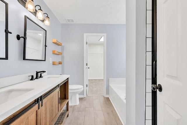 1186 Hawthorn Ln, Grayson, GA 30017 - bathroom with double vanity, a bath, toilet, baseboards, and a spacious closet
