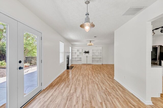 1186 Hawthorn Ln, Grayson, GA 30017 - foyer with healthy amount of natural light, light wood-type flooring, a textured ceiling, and baseboards