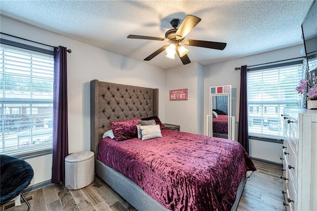 bedroom featuring a textured ceiling, a ceiling fan, and wood finished floors