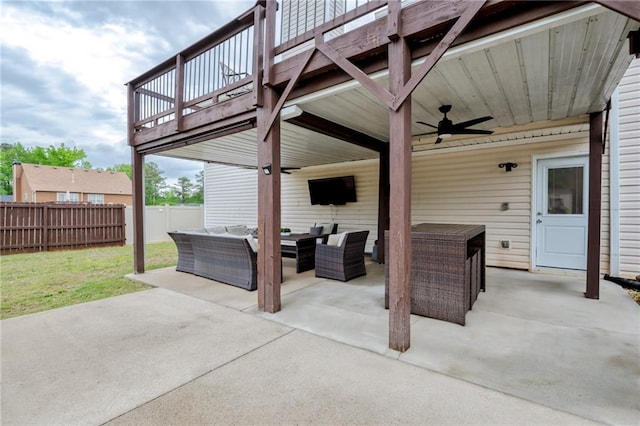 view of patio / terrace with an outdoor living space, fence, and a ceiling fan