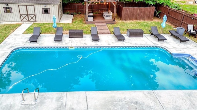 view of pool with a fenced in pool, a patio area, an outbuilding, and a fenced backyard