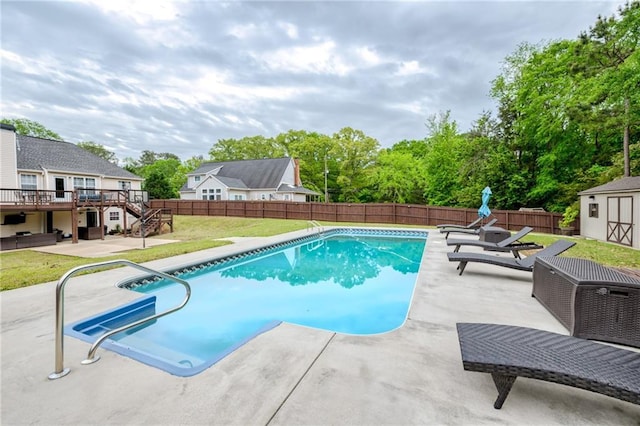 view of swimming pool with a patio area, an outdoor structure, a fenced backyard, a storage shed, and a lawn