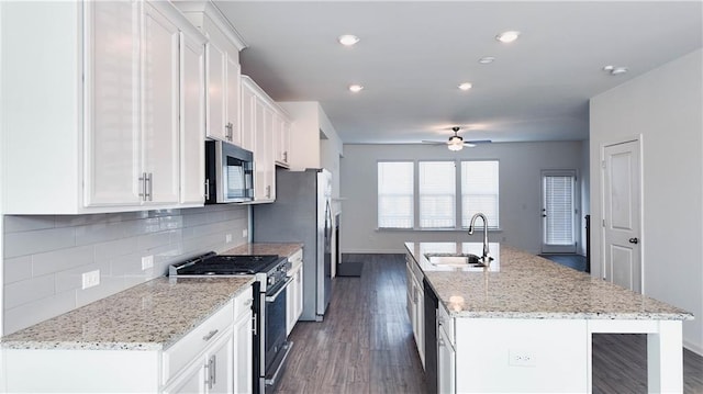 kitchen with sink, a center island with sink, white cabinets, and appliances with stainless steel finishes