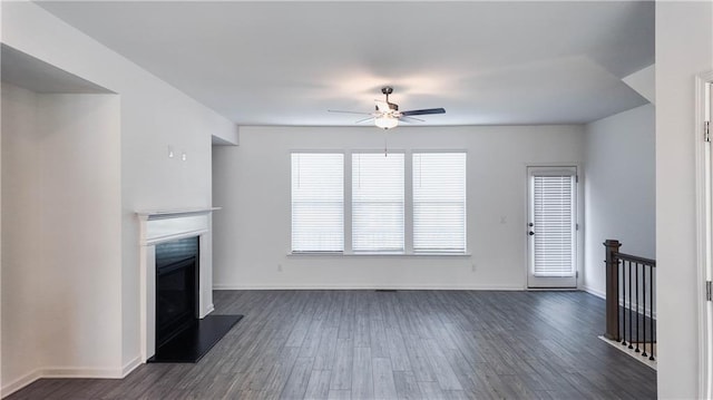 unfurnished living room with ceiling fan and dark wood-type flooring