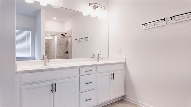 bathroom with a shower with door, vanity, and tile patterned flooring