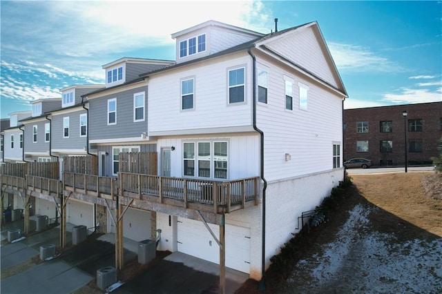 back of property featuring a garage and cooling unit