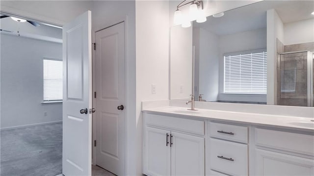 bathroom with vanity, ceiling fan, and walk in shower