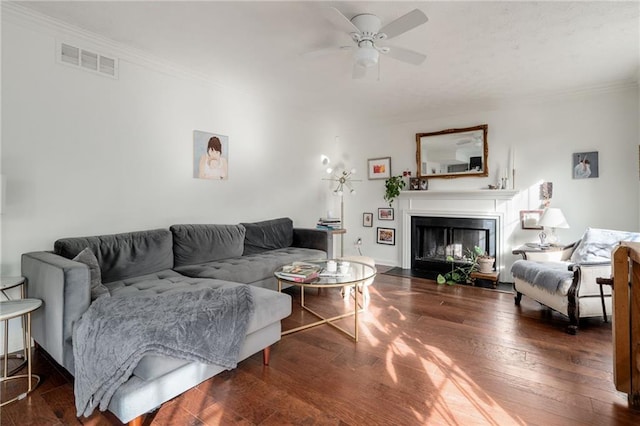 living room with crown molding, dark wood-type flooring, and ceiling fan