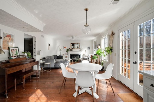 dining room with dark hardwood / wood-style flooring, ornamental molding, french doors, and a textured ceiling