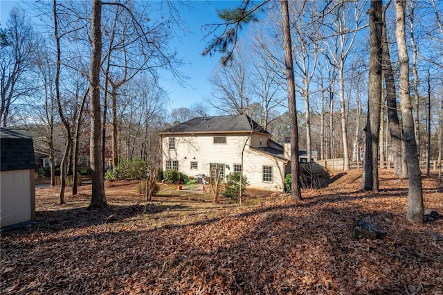 rear view of house featuring a shed