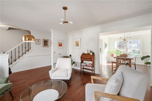 living room featuring crown molding, dark hardwood / wood-style floors, and a notable chandelier