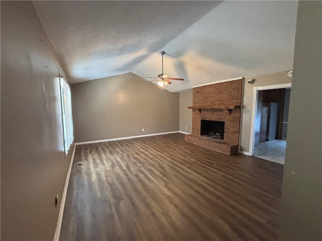 440 Ward Rd, Ellenwood, GA 30294 - unfurnished living room with ceiling fan, vaulted ceiling, wood finished floors, baseboards, and a brick fireplace