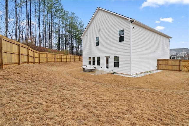 back of property with a fenced backyard and a patio