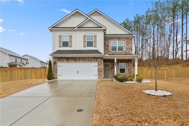 craftsman-style home with an attached garage, stone siding, concrete driveway, and fence