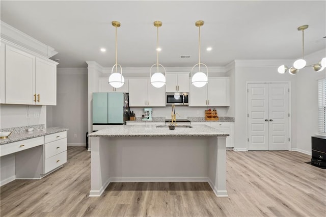 kitchen featuring white cabinets, stainless steel microwave, light wood-type flooring, freestanding refrigerator, and crown molding