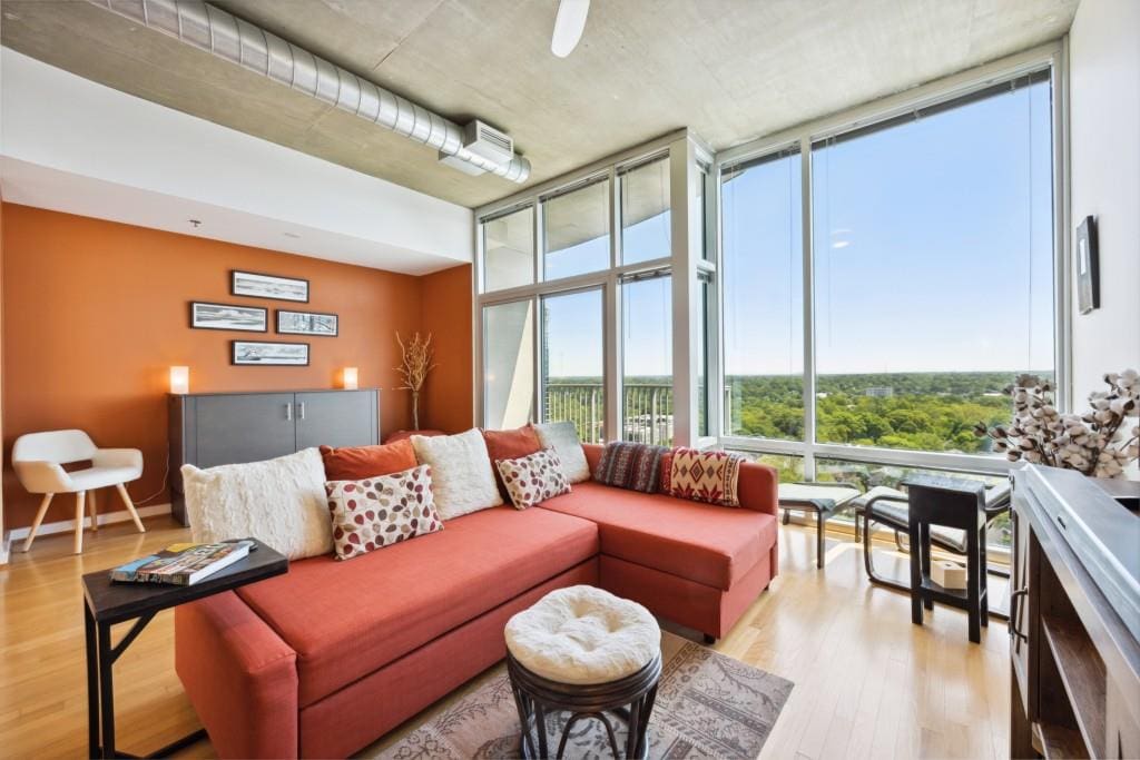 living room with expansive windows and light hardwood / wood-style floors