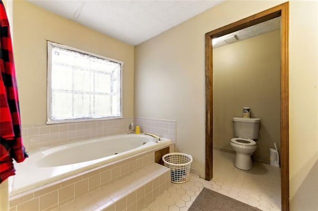 bathroom featuring toilet, a garden tub, baseboards, and tile patterned floors