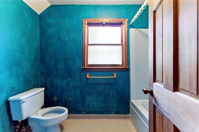 full bathroom featuring a bathtub, a shower, toilet, a textured ceiling, and tile patterned flooring