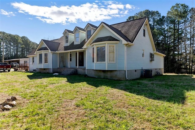 view of front of house with a front lawn and central air condition unit