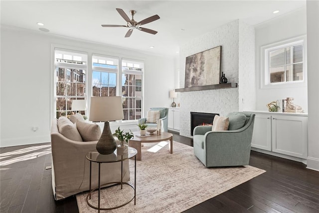 living area featuring recessed lighting, a fireplace, dark wood-style flooring, and baseboards