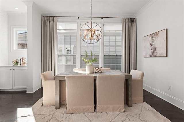 dining room with ornamental molding, wood finished floors, baseboards, and a chandelier