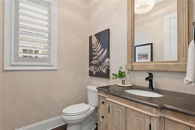 half bath with vanity, toilet, and tasteful backsplash