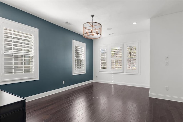 unfurnished dining area featuring visible vents, dark wood finished floors, recessed lighting, an inviting chandelier, and baseboards