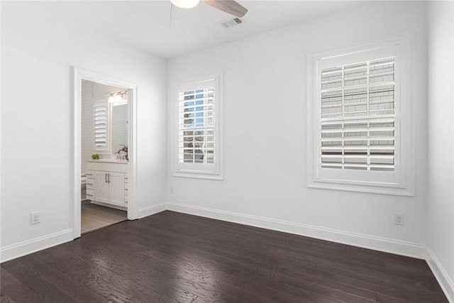 unfurnished bedroom with visible vents, baseboards, dark wood-style floors, and ensuite bathroom