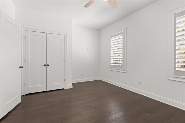 unfurnished bedroom with ceiling fan, a closet, baseboards, and dark wood finished floors