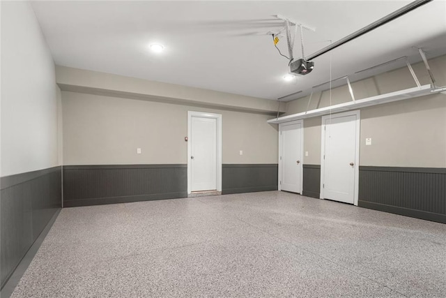 garage featuring a garage door opener and a wainscoted wall