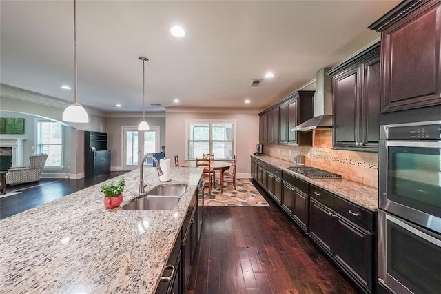 265 Enfield Ln, Mcdonough, GA 30252 - kitchen with a sink, wall chimney range hood, stainless steel appliances, light stone counters, and dark wood finished floors