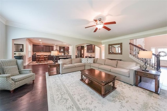 265 Enfield Ln, Mcdonough, GA 30252 - living area featuring arched walkways, ornamental molding, a ceiling fan, dark wood-style floors, and stairs