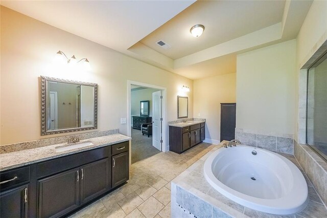 265 Enfield Ln, Mcdonough, GA 30252 - full bath featuring a bath, two vanities, a tray ceiling, and tile patterned flooring