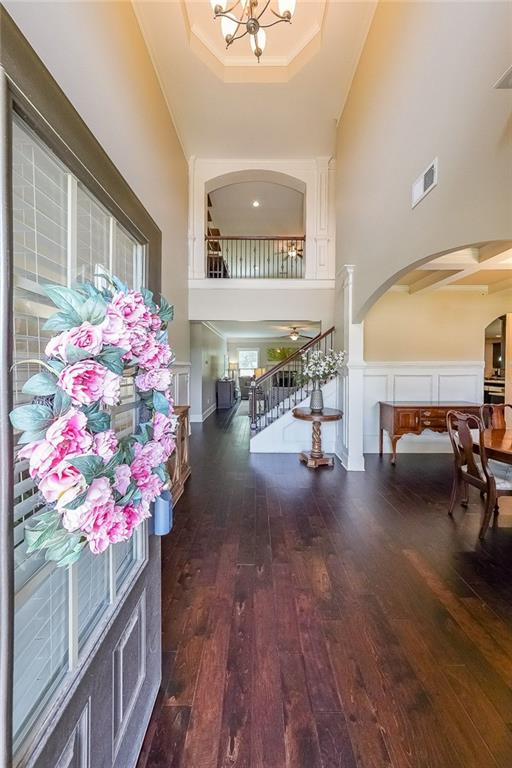 265 Enfield Ln, Mcdonough, GA 30252 - entryway featuring arched walkways, a high ceiling, wood-type flooring, a raised ceiling, and a chandelier
