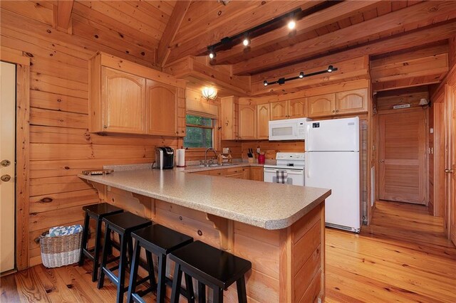 2374 Woodring Branch Rd, Chatsworth, GA 30705 - kitchen featuring white appliances, light brown cabinets, a peninsula, wood walls, and light countertops