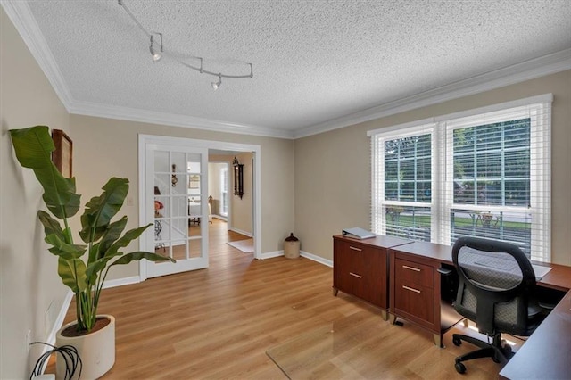 office with baseboards, ornamental molding, light wood-type flooring, and a textured ceiling