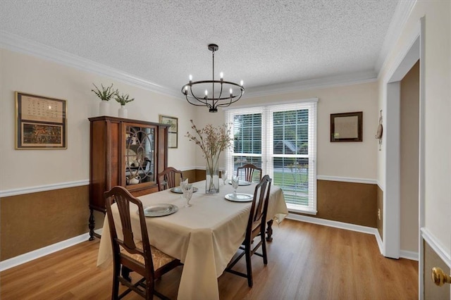 dining area with a textured ceiling, wood finished floors, and a chandelier