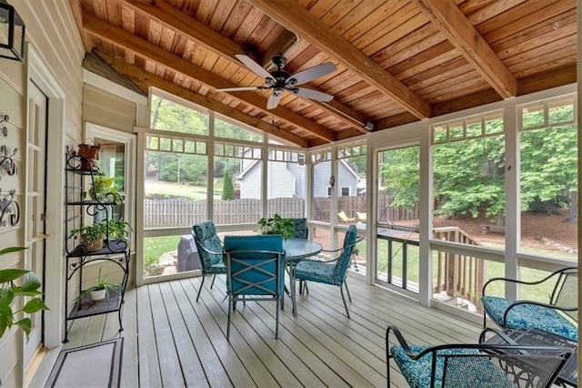 sunroom / solarium featuring plenty of natural light, ceiling fan, outdoor dining area, and beam ceiling