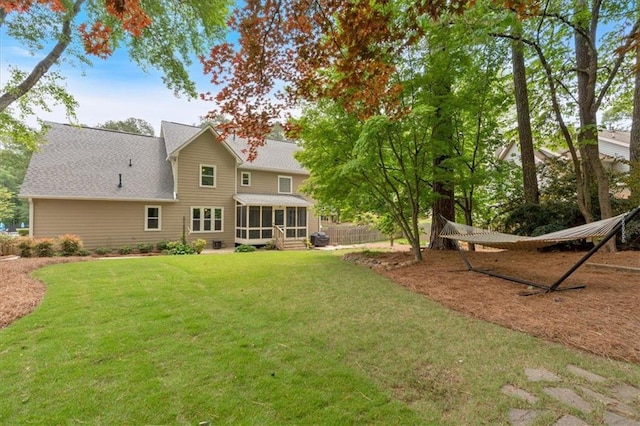 back of property with a yard and a sunroom